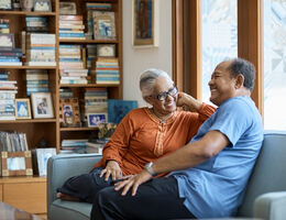 Two older adults laugh and talk.